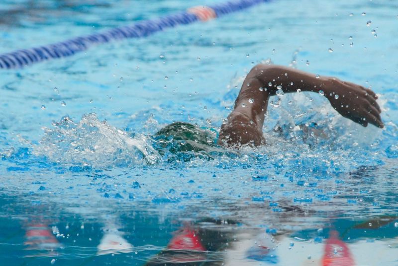 Partially submerged swimmer in swimming pool next to lane line